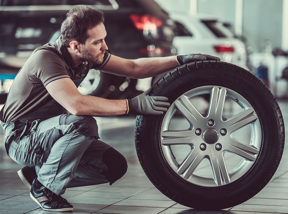 Mechanic looking over a new tyre - Tyres Killingworth | Westmoor MOT Centre